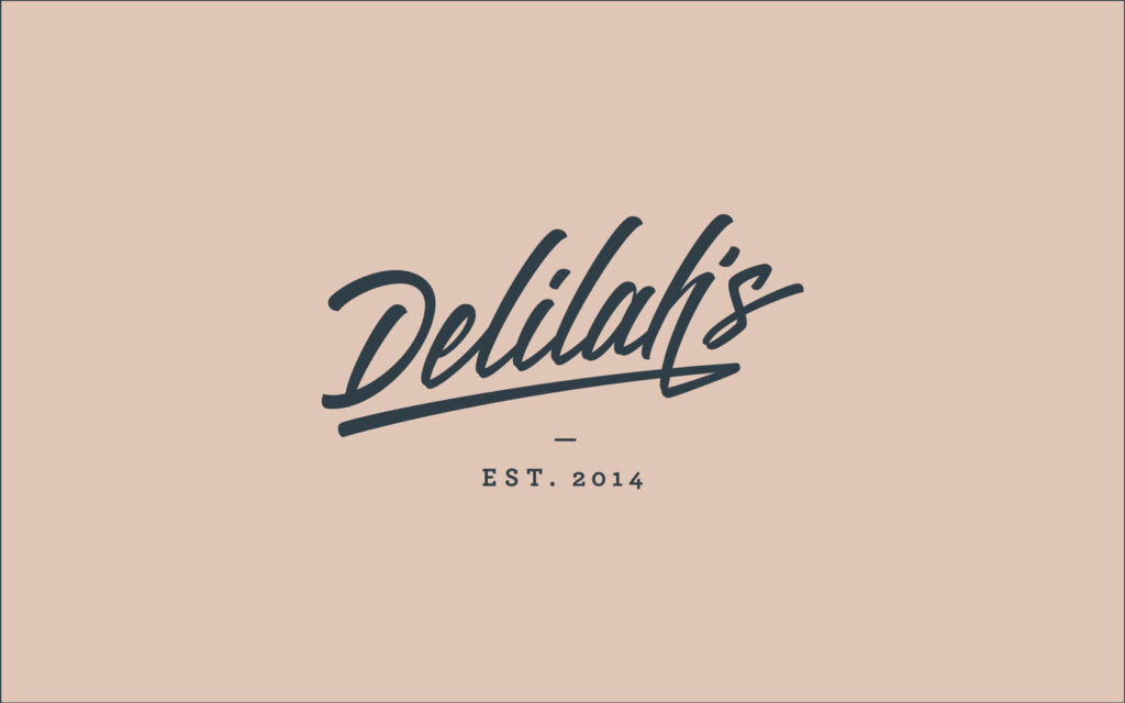 Delilah’s. Brand logo in charcoal blue on beige background